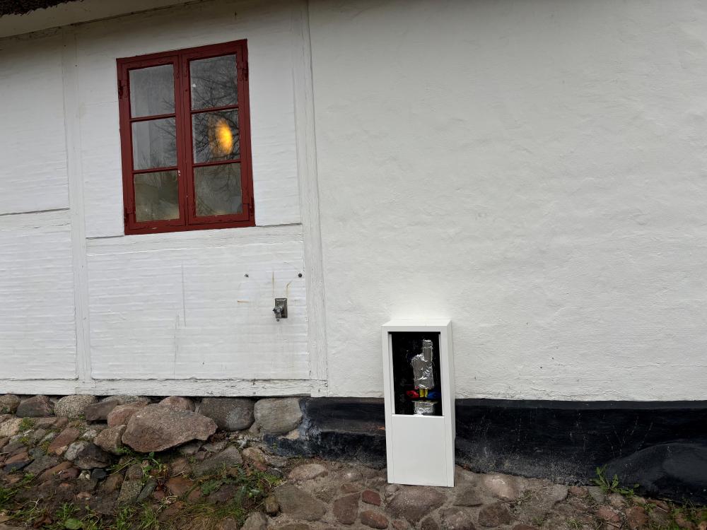 Huset på Gl. Lundtoftevej 31 blev opført i 1808. De store kampesten som fundament forhindrer boring til fjernvarmerør dér. Bag boksen har man derfor boret rør ind i stuen, hvor de er pakket ind i et træskab og ført videre ind midt i huset.